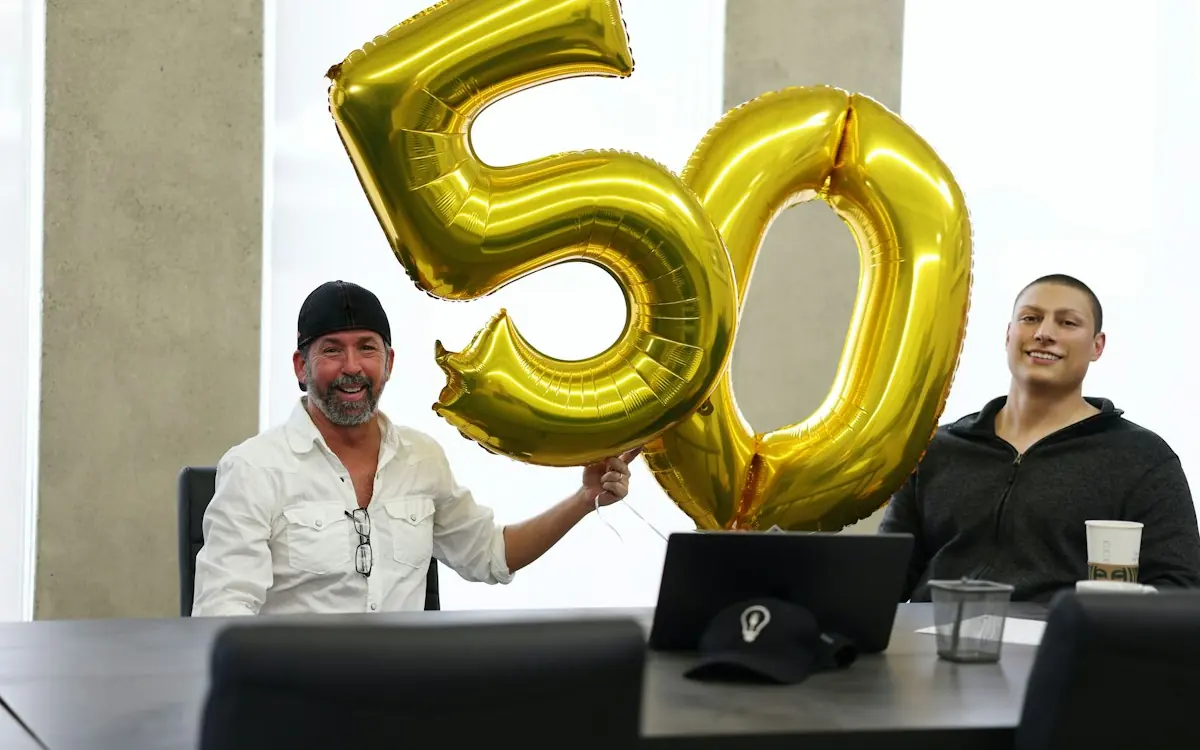 Friends celebrating a 50th birthday with gold number 50 balloons
