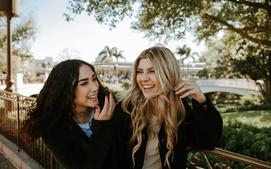 Two best friends laughing together outdoors