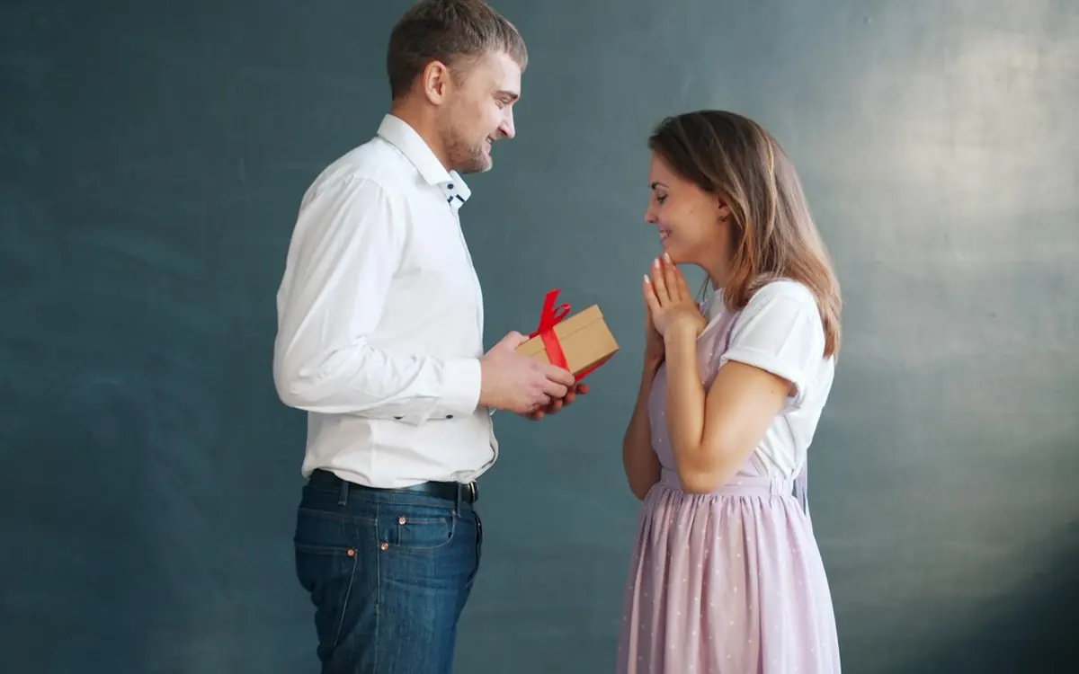 A man surprising his girlfriend with a small gift