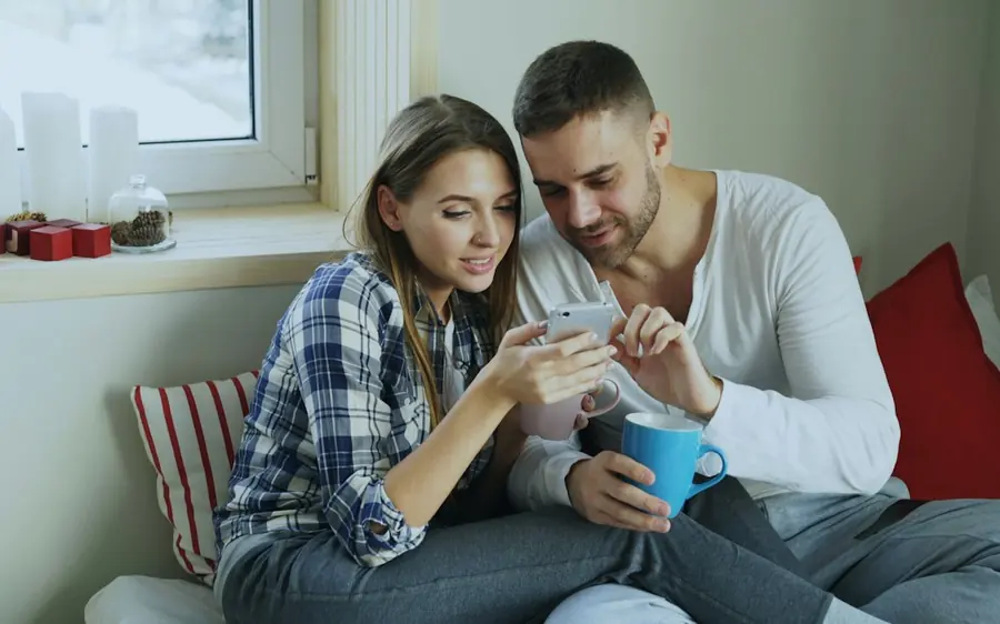 A couple looking at a phone together and smiling