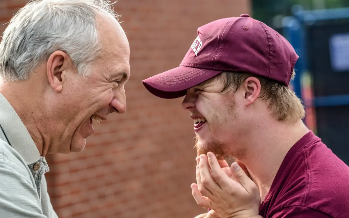 A father and his adult son laughing together