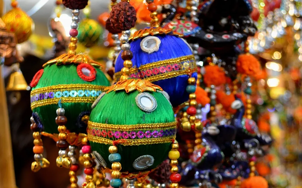 Bright hanging Diwali decorations with beads and embroidered balls at a market