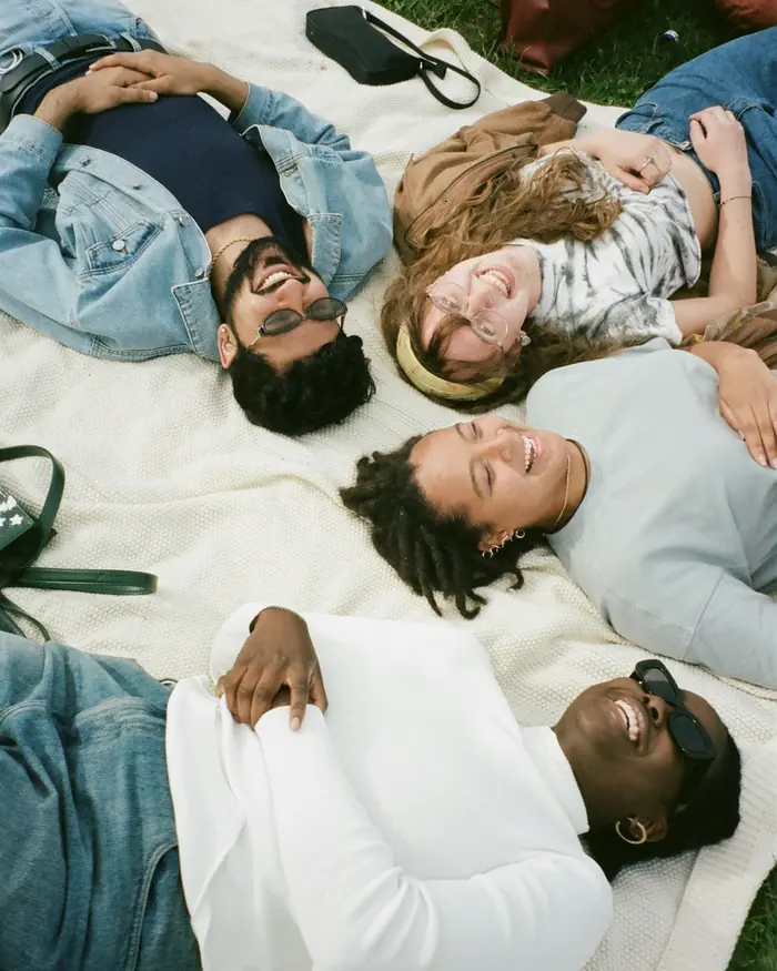 Friends lying together on a picnic blanket