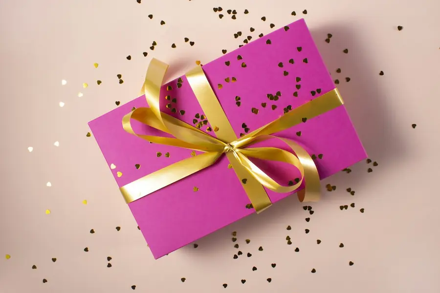 A wrapped birthday gift with a gold ribbon