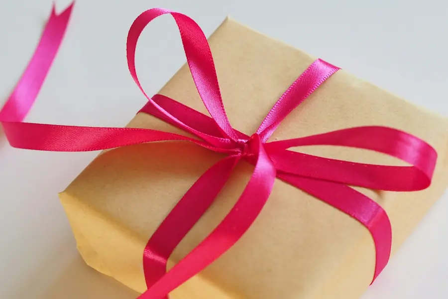 A birthday gift wrapped with a bright pink ribbon