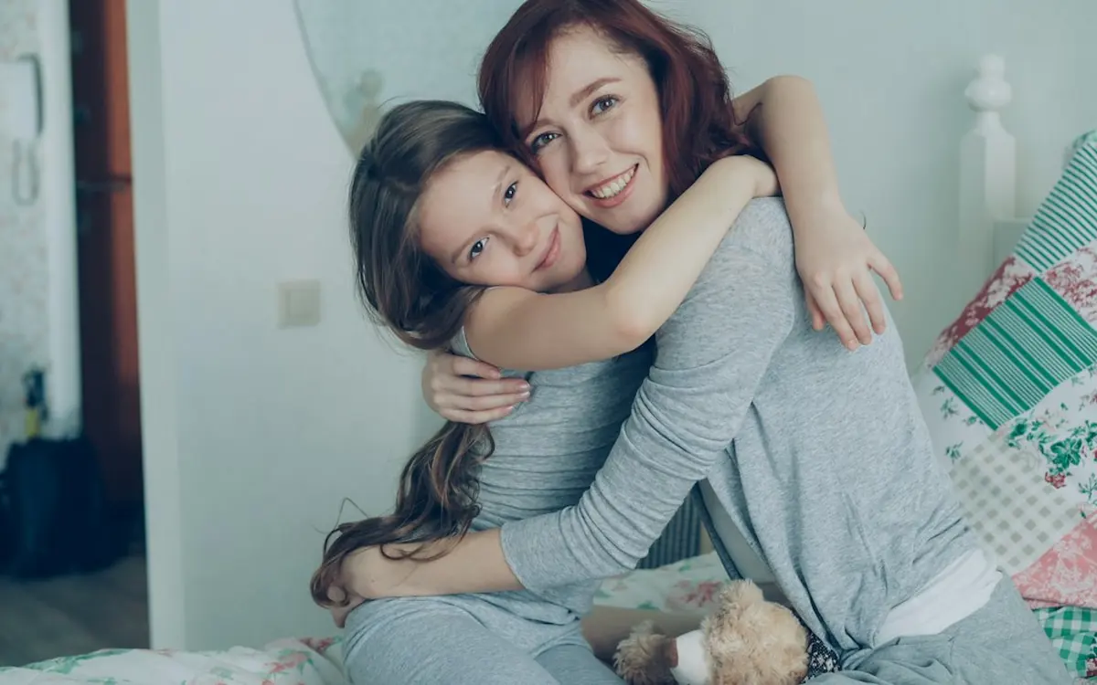 A daughter hugging her smiling mother at home