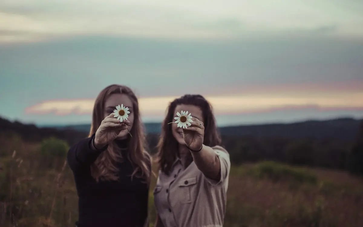 Two sisters taking photos of each other outdoors